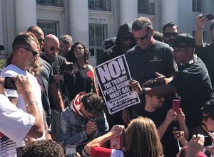 Refuse Fascism poster in front of Milo Yiannopoulos on campus
